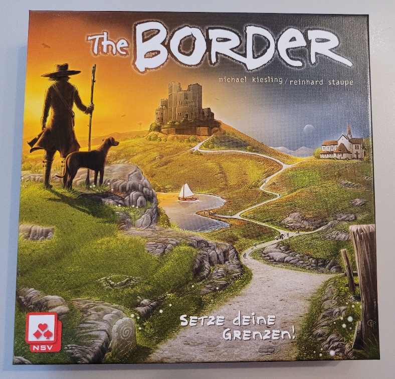 Das Cover von "The Border" auf dem eine kurvige Straße zu sehen ist. Am Rand steht ein Mann mit Stab und Hut, daneben sein Hund.