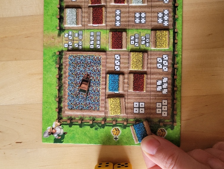 Das Spielertableau von "Tulpenfieber" mit bereits ausgelegten Plättchen. Vier Würfel die Eins zeigen und ein Plättchen das an die passende Stelle gelegt wird.