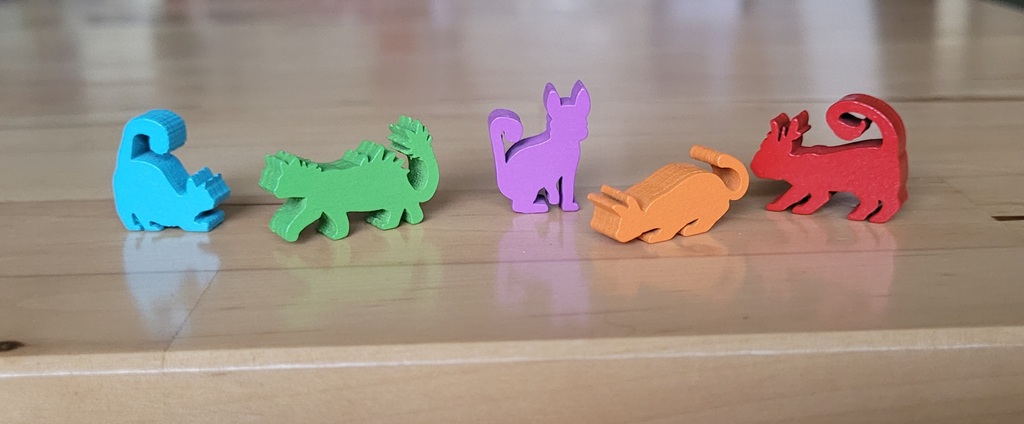 Fünf bunte Holzfiguren in Katzenform in verschiedenen Positionen gehören bei "Die Insel der Katzen" zum Spielmaterial. 