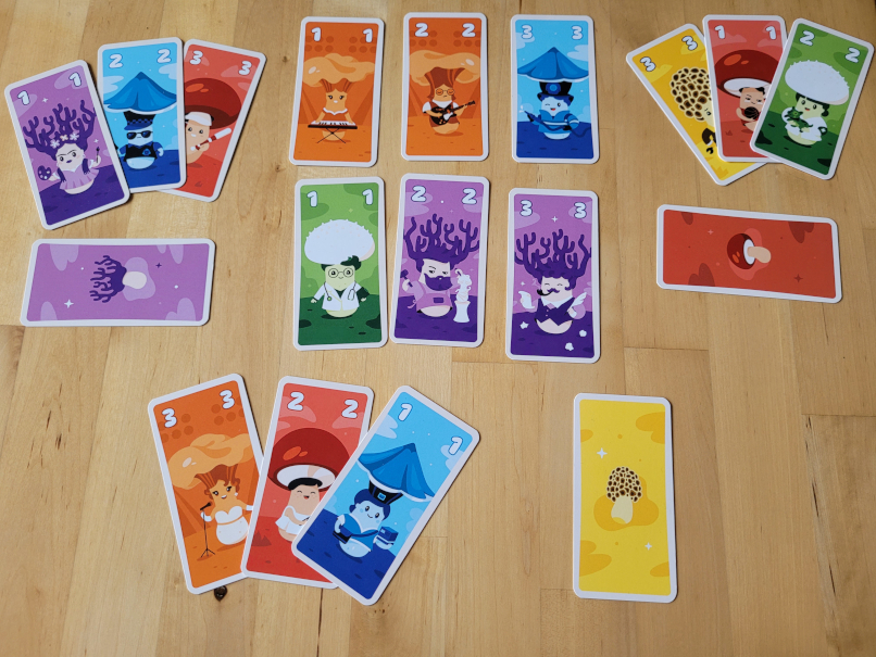 Viele bunte Pilzkarten aus "Kinoko" liegen auf dem Tisch.