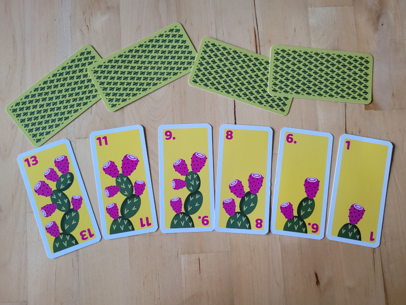 Sechs Karten mit Zahlen zwischen 1 und 13 und je einem Kaktus mit verschieden vielen Kaktusfeigen.