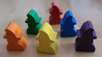 Sechs Spielfiguren aus Holz, die wie Zauberer mit Hüten aussehen.