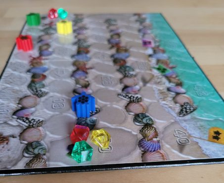 Der Spielplan von "Eco: Coral Reef" mit den Schildkröten-Spielfiguren, Kristallen und vielen Muscheln.