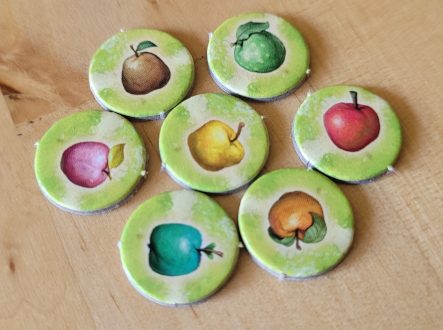 Sieben Plättchen von "Applejack" zeigen verschiedenfarbige Äpfel.