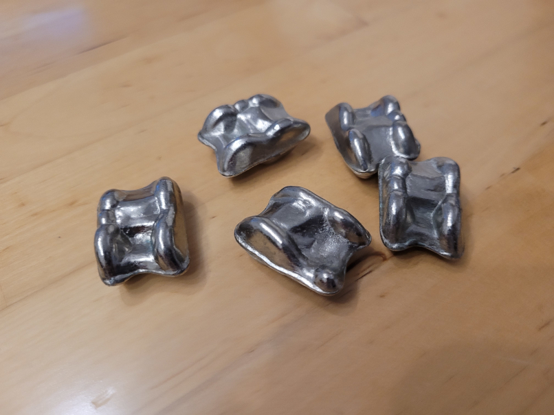 Fünf metallene Spielsteine.