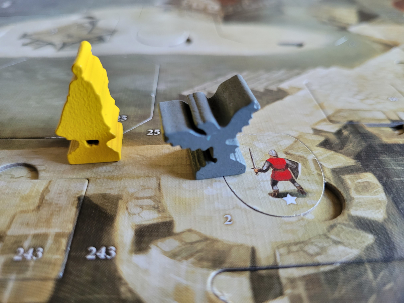 Die gelbe Figur von Lady Marian und die Figur des grauen Raben stehen neben einem Wache-Plättchen auf dem Spielplan von "Die Abenteuer des Robin Hood".