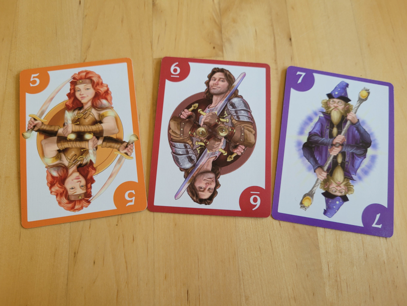 Drei Karten unterschiedlicher Farbe mit den Zahlen Fünf, Sechs und Sieben.