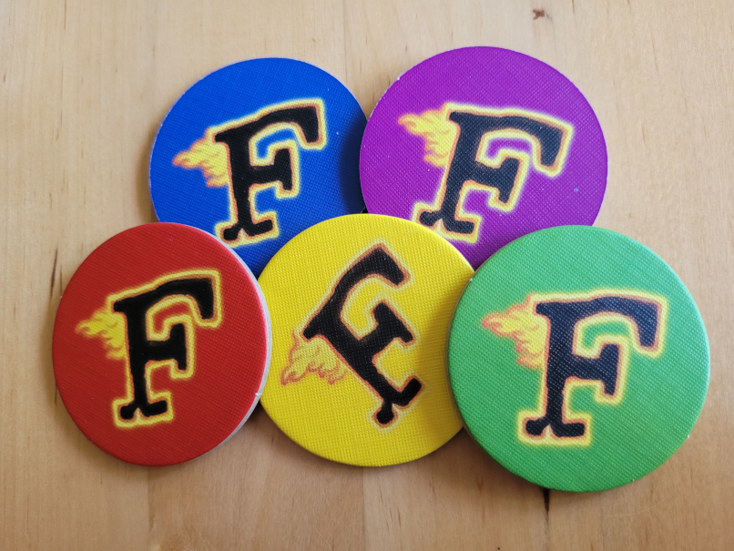 Fünf runde Plättchen mit einem brennenden "F".