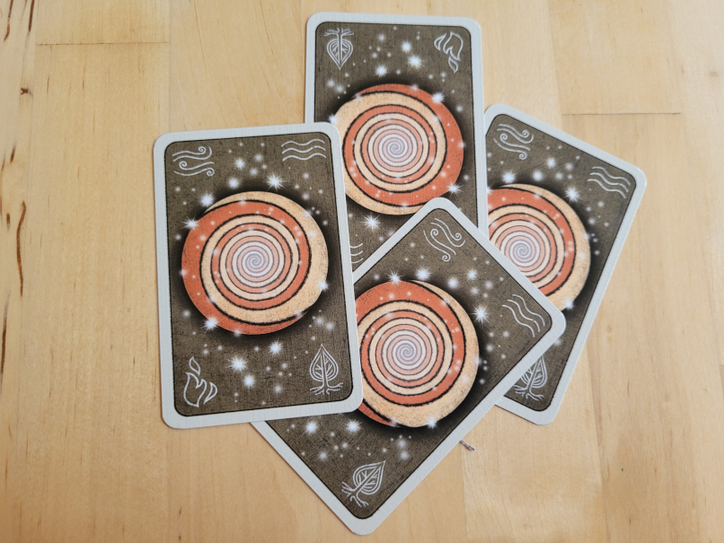 Vier Karten mit einer Spirale und Element-Symbolen.
