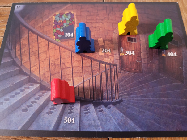 Vier Spielfiguren stehen auf einer großen Karte, die eine geschwungene Treppe, zwei Türen, ein Fenster und Zettel zeigt.