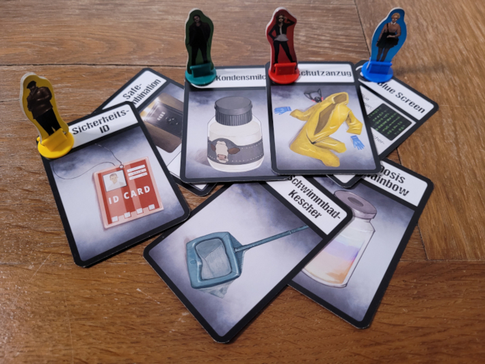 Die vier Spielfiguren stehen auf verschiedenen Gegenstandskarten.