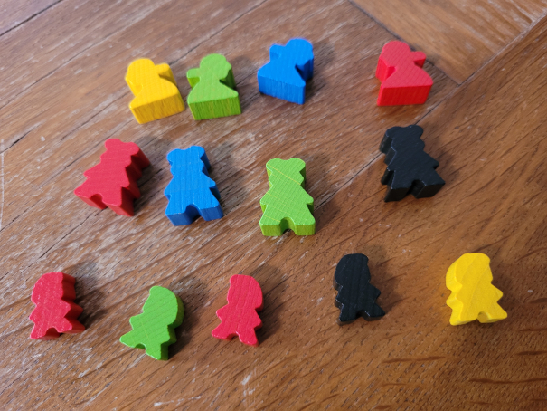 Drei verschieden geformte Spielfiguren in unterschiedlichen Spielerfarben.
