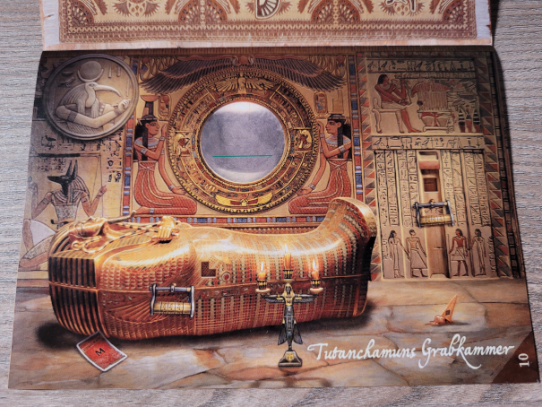 Eine Seite aus dem Abenteuerbuch von "Exit – Das Spiel: Die Grabkammer des Pharao" zeigt einen Sarkophag und viele Hyroglyphen.