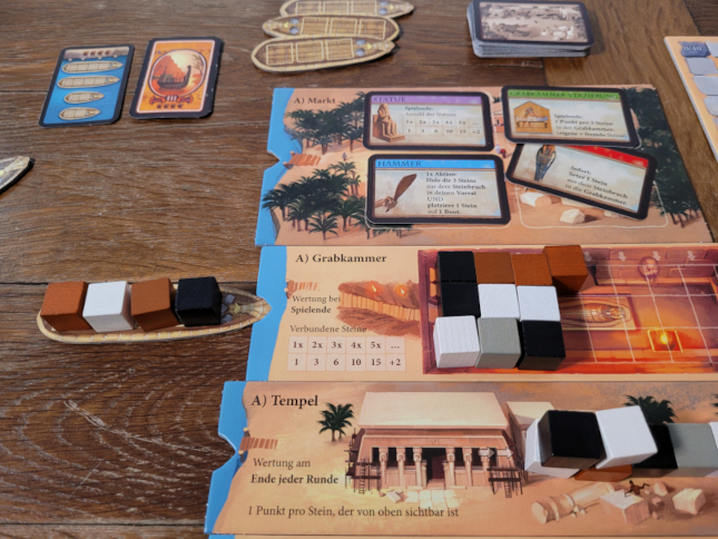 Spielmaterial von "Imhotep" mit Karten, Holzwürfeln und Karten.