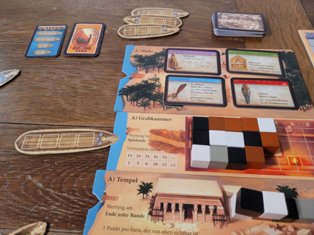 Spielmaterial von "Imhotep" mit Karten, Holzwürfeln und Karten.