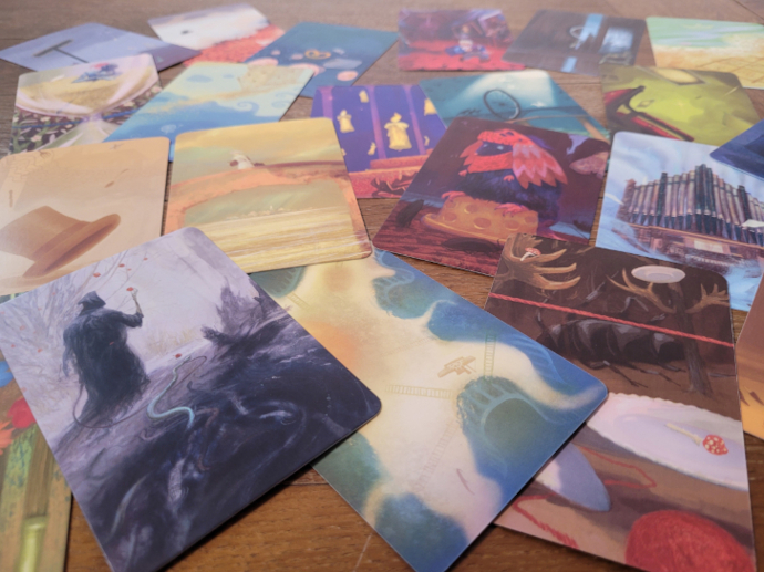 Auf einem Tisch liegen verteilt Karten mit bunten Bildern.