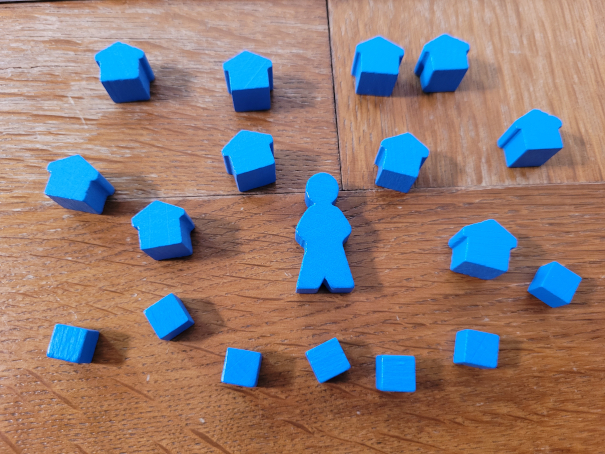 Das Material eines Spielers mit einer Figur, Häuschen und Würfeln in Blau.