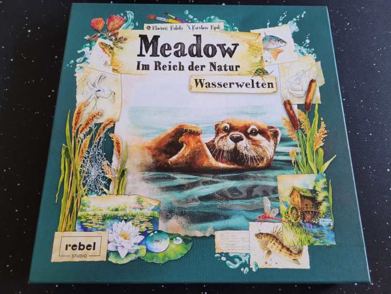 Das Cover von der ERweiterung "Wasserwelten" von "Meadow" zeigt einen auf dem Rücken schwimmenden Otter, der die Pfoten übereinander gelegt hat und den Betrachter anschaut.