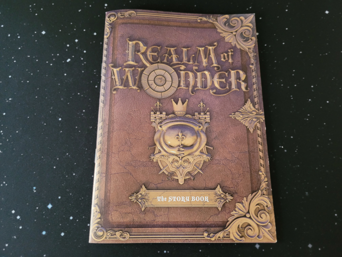 Ein auf alt gemachtes Heft, das nach einem beschlagenen Buch aussieht mit der Aufschrift "Realm of Wonder – The Story Book".