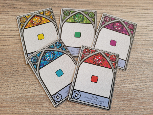 Fünf Geheime Auftragskarten aus Sagrada zeigen je eine Würfelfarbe.