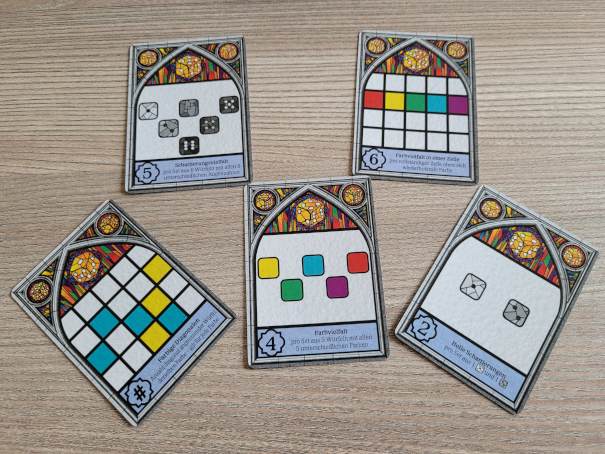 Fünf Öffentliche Auftragskarten aus Sagrada zeigen Farbfelder und Würfelsymbole.