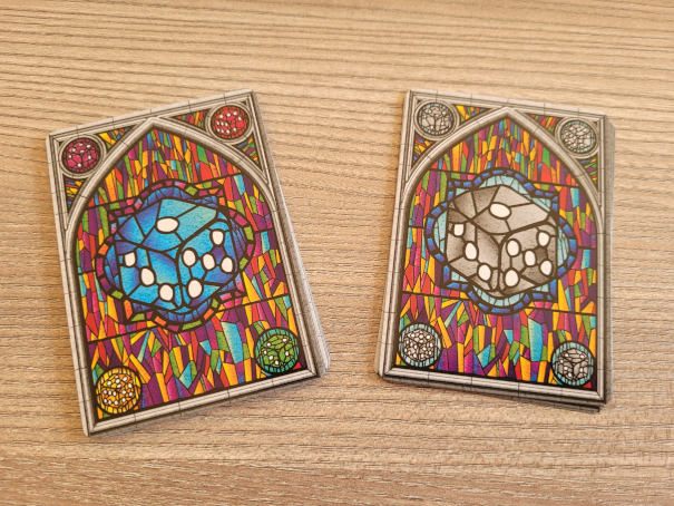Zwei Kartenstapel zeigen einmal einen blauen und einmal einen grauen Würfel.