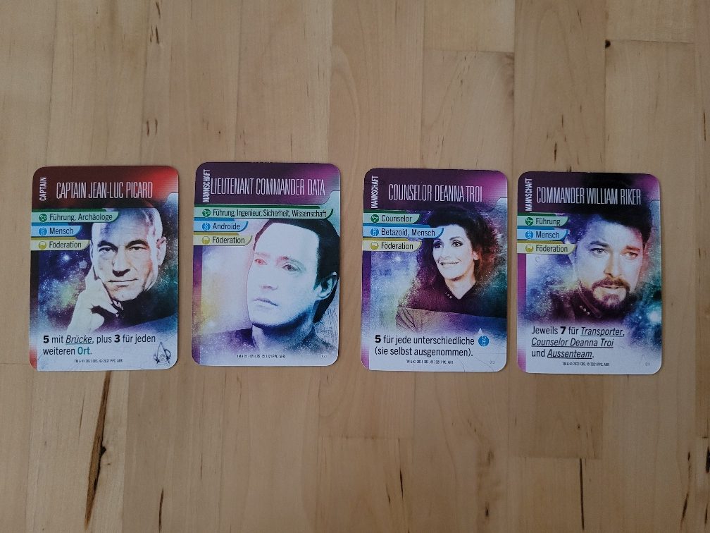 Vier Karten aus "Star Trek – Missionen" zeigen bekannte Charaktere aus der "The Next Generation"-Serie von "Star Trek": Captain Picard, Lieutenant Commander Data, Counselor Troi und Commander Riker.
