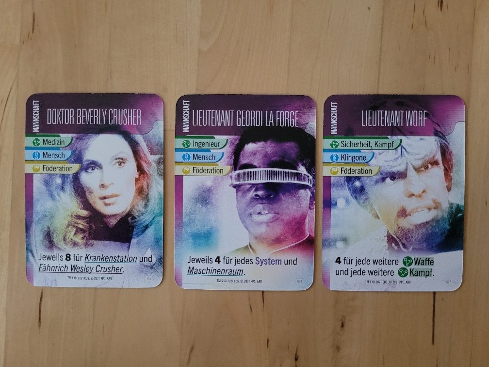 Vier Karten aus "Star Trek – Missionen" zeigen bekannte Charaktere aus der "The Next Generation"-Serie von "Star Trek": Doktor Crusher, Lieutenant La Forge, Lieutenant Worf.