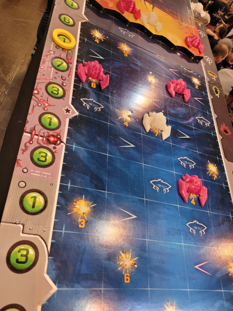 Der Spielplan von "Under Falling Skies" mit pinken und weißen Raumschiffen.