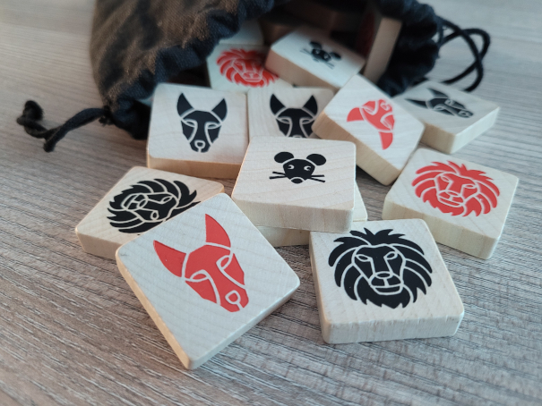 Spielsteine aus "Tokan" zeigen rote und schwarze Tierköpfe: Löwe, Maus und Schakal.