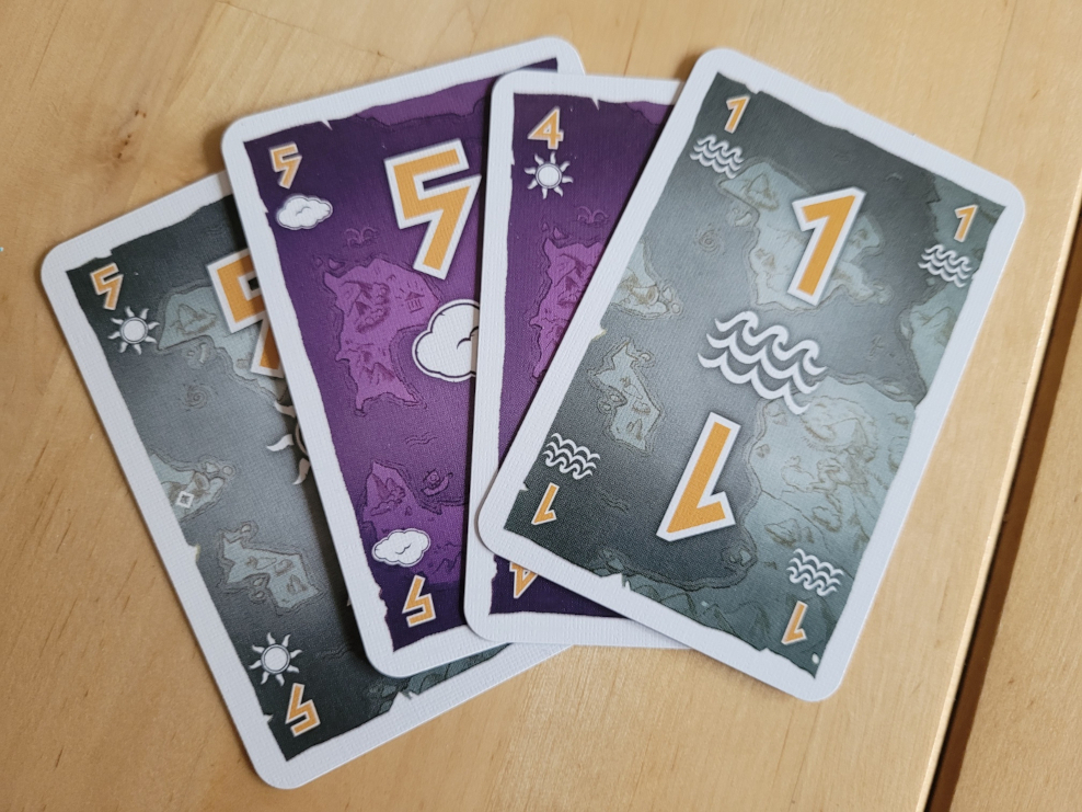 Vier Karten mit Wettersymbolen und den Zahlen Fünf, Fünf, Vier und Eins. Zwei sind lila, zwei sind grau.
