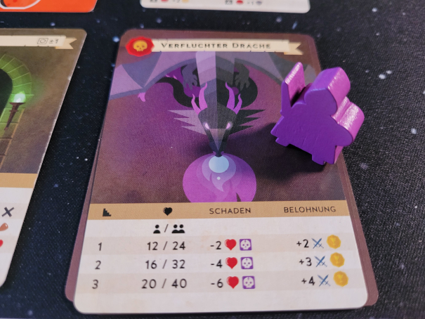 Eine lilafarbene Spielfigur steht auf der Karte "Verfluchter Drache".