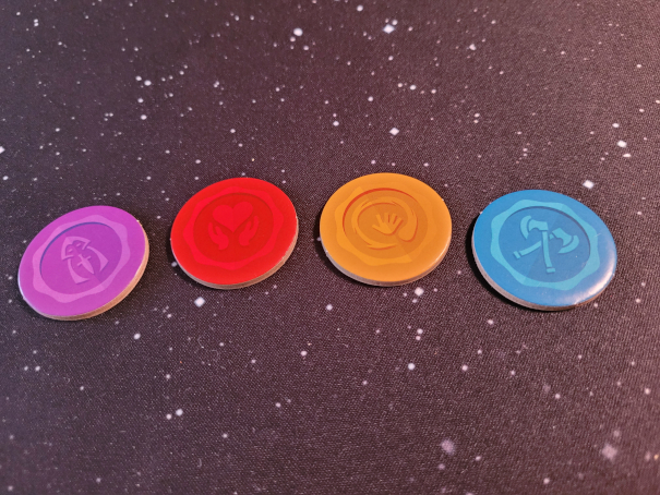Vier runde Markerplättchen in Lila, Rot, Gelb und Blau aus "Mini Rogue".
