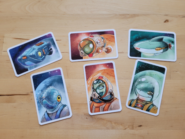 Je drei Karten mit Raumschiffen und Charakteren.