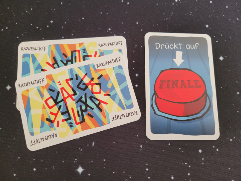 Zwei Karten mit Razupaltuff und eine mit einem großen roten Knopf, auf dem "Finale" steht.