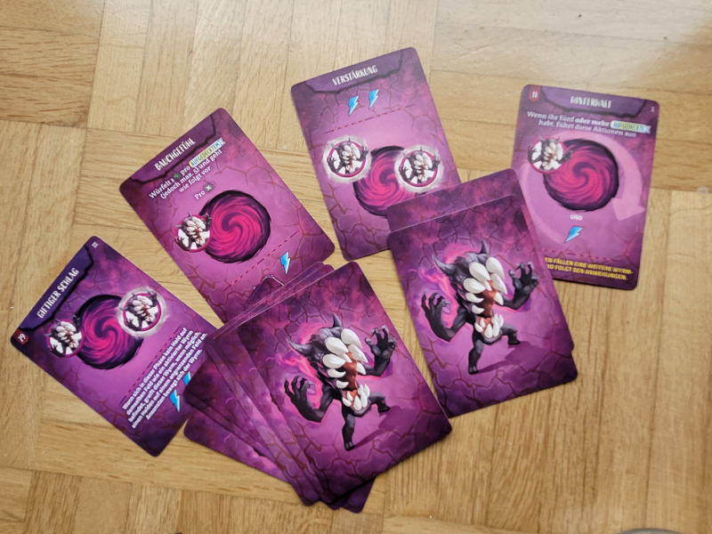 Ein Haufen lilafarbener Karten mit Wyrms und Symbolen.