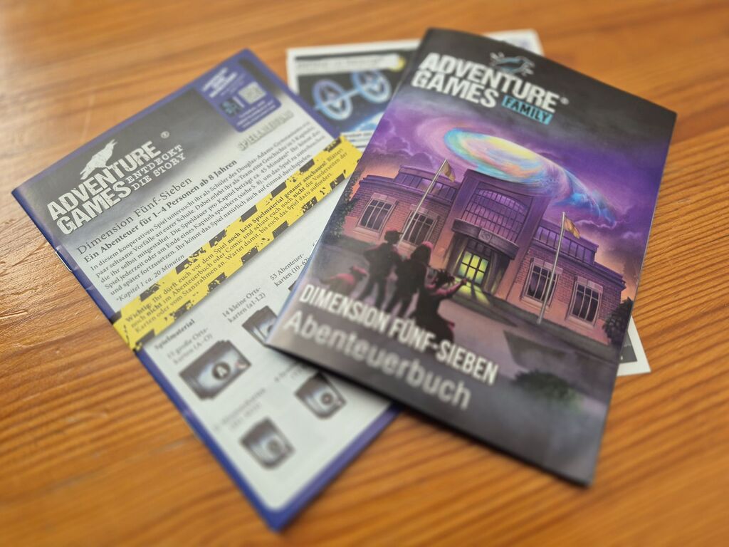 Drei Hefte, die zum Spielmaterial gehören: Regeln, ein Comic und das Abenteuerbuch.