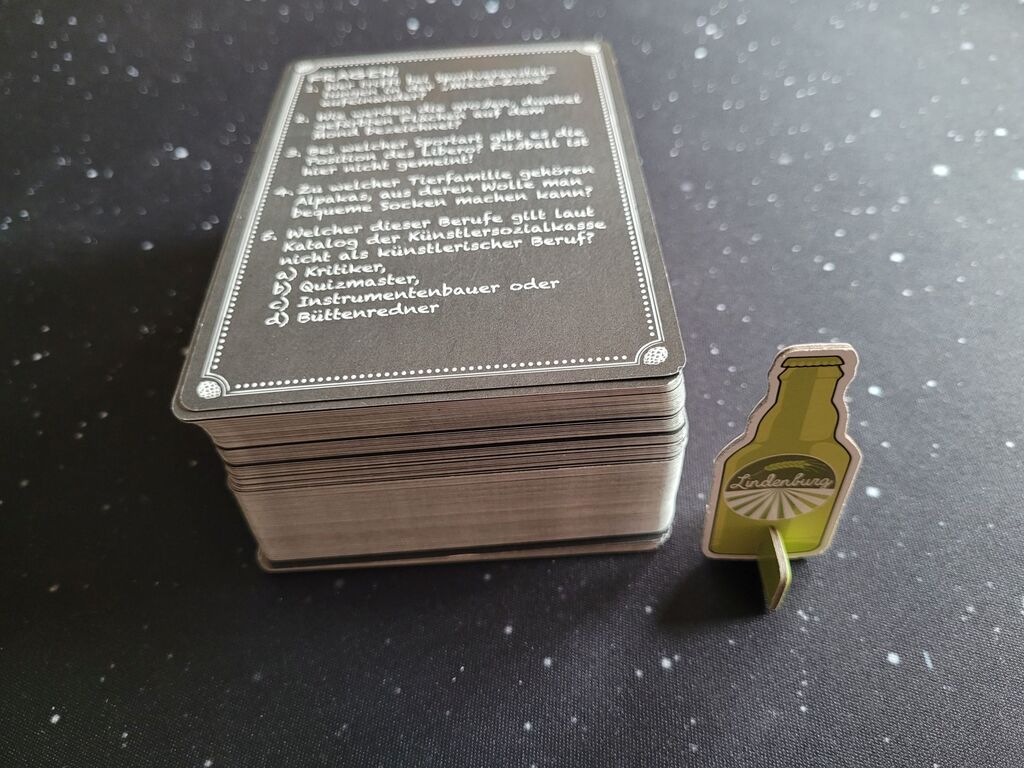 Ein Stapel Karten mit Text, daneben steht eine Spielfigur.