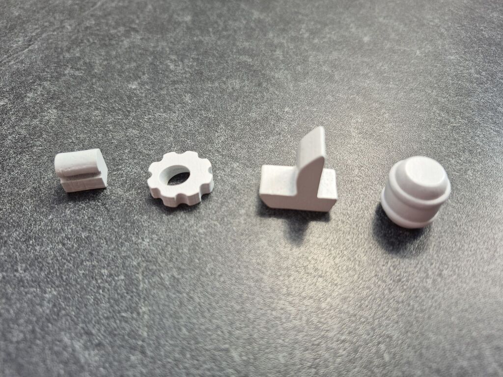 Vier Spielfiguren in verschiedenen Formen.