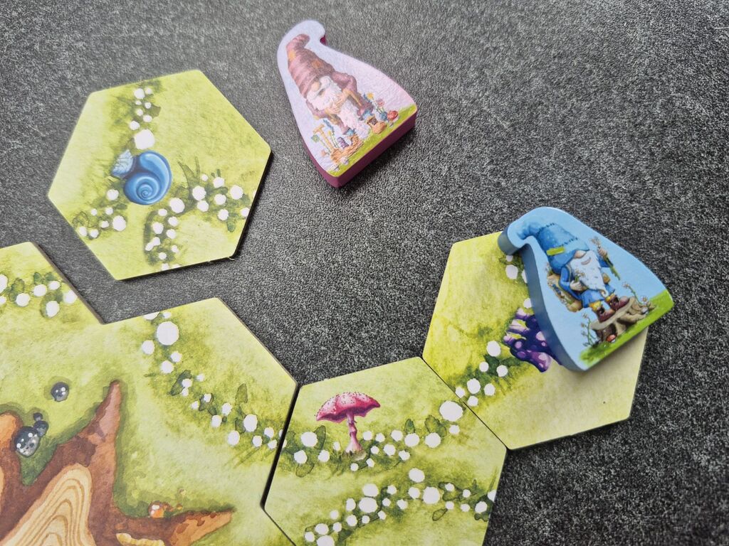 Zwei Spielfiguren und einige Plättchen.