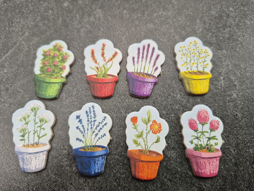 Acht Plättchen mit Blumen in Töpfen.