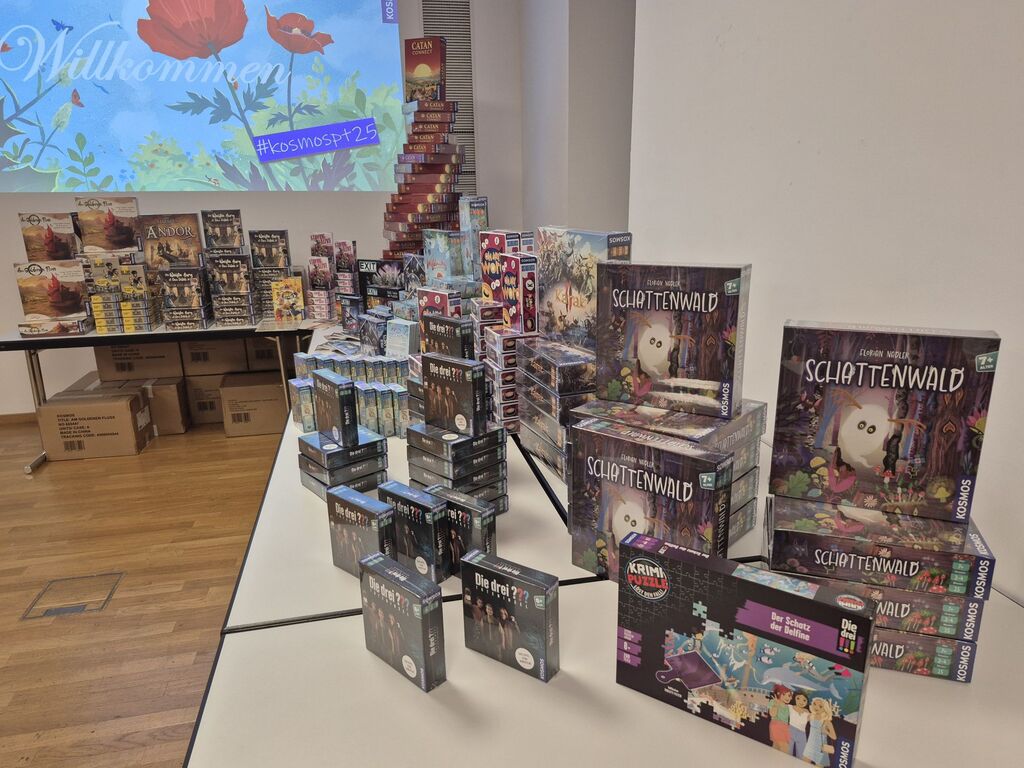 Viele Spielestapel auf mehreren Tischen.