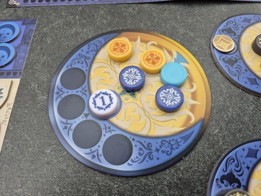 Auf einem Plättchen liegen runde Spielsteine.