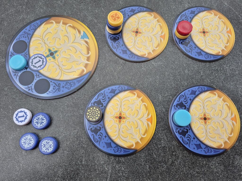 Plättchen und runde Spielsteine in veränderter Anordnung.
