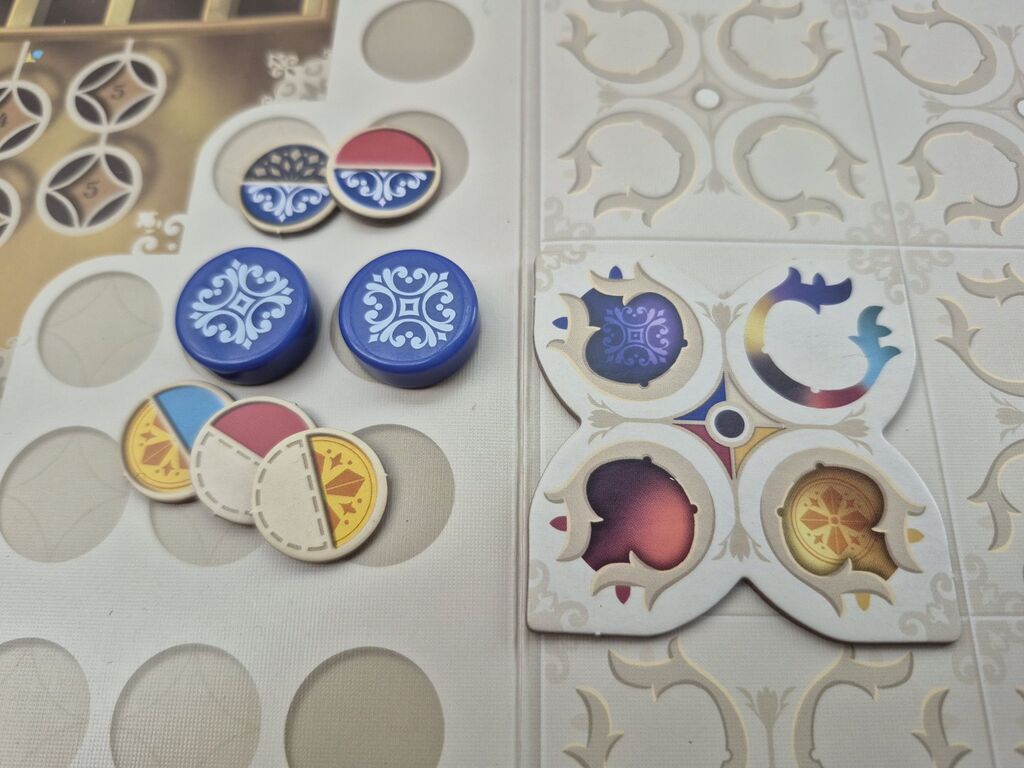 Zwei runde Spielsteine, darüber zwei und darunter drei Marker.