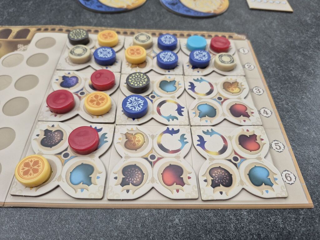 Ein Teil des Spielertableaus mit Plättchen und Spielsteinen.