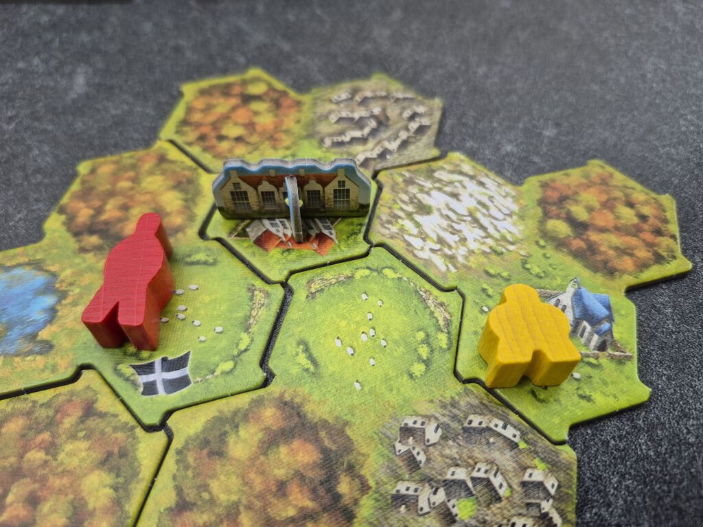 Ein Häuschen als Pappaufsteller steht auf Spielplanteilen von "Cornwall".