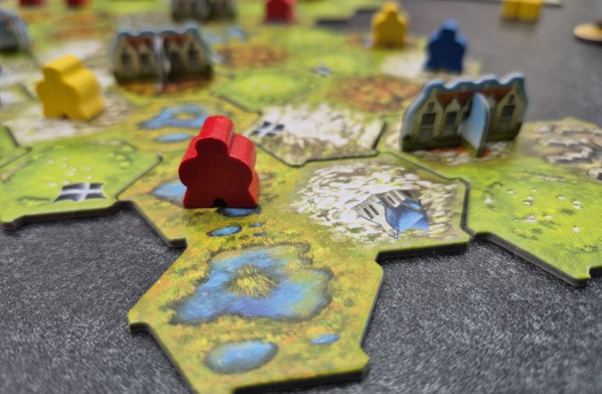 Auf dem aus Plättchen zusammengesetzten Spielplan stehen Cottages und Meeple.