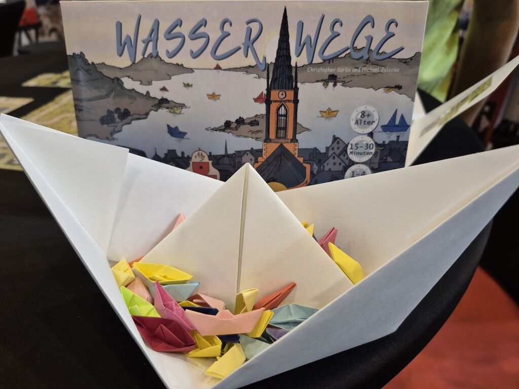 Ein gefaltetes Papierboot mit vielen kleinen Papierbooten drin.