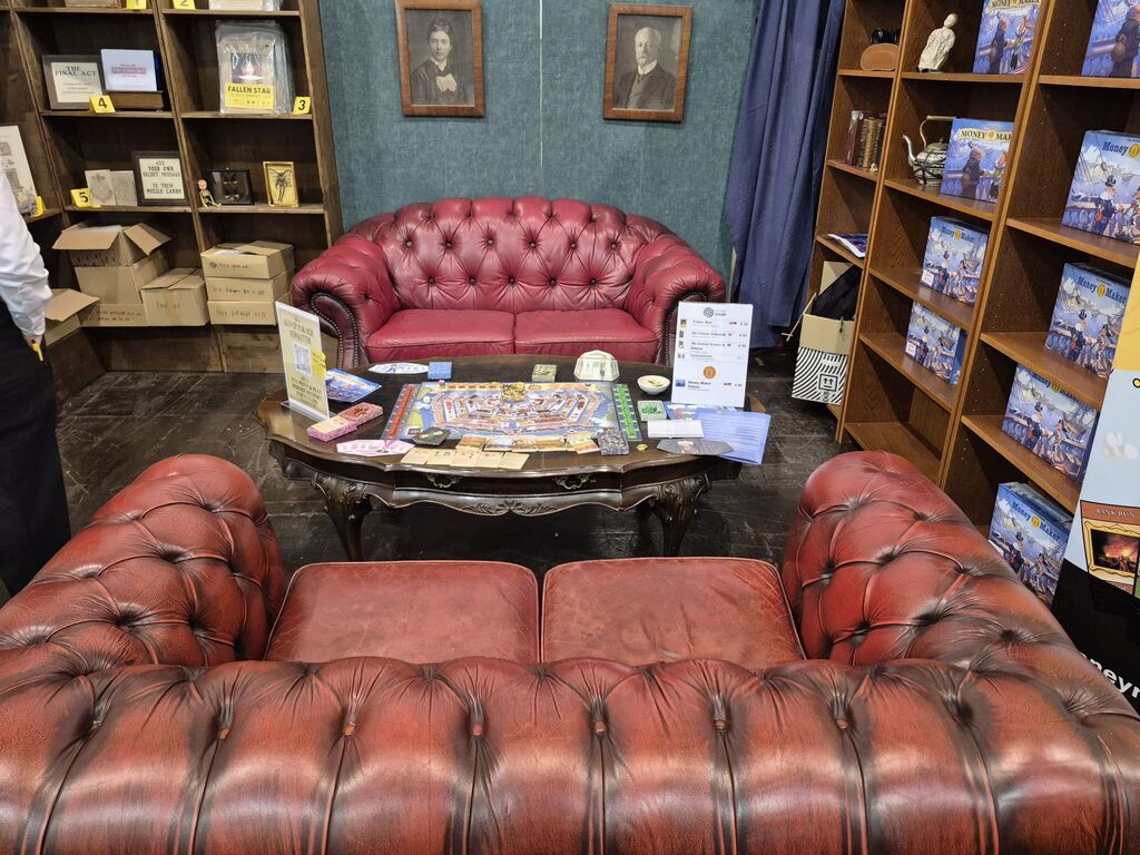 Zwei Sofas, dazwischen ein Tisch, daneben Regale.